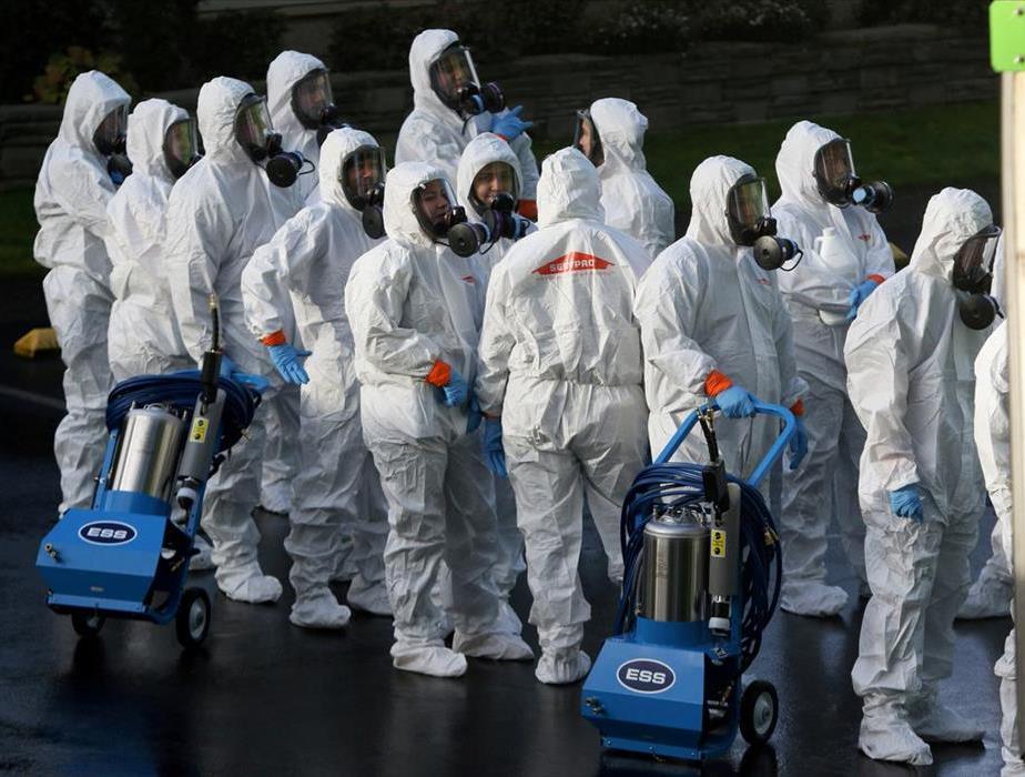 Members of a SERVPRO cleanup crew wearing hazardous material suits